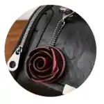 Ein rotes Lederrosen-Schlüsselanhänger an einer schwarzen Tasche, ideal für modisches Accessoire und Geschenke, hochwertige Verarbeitung, trendiges Design.