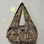 Laptoptasche mit Leopardenmuster, beige Lederriemen, Reißverschlüssen und dekorativen Elementen, ideal für modebewusste Frauen.