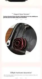 Schwarze Leder-Tasche mit silberner Reißverschluss und rotem Rosenanhänger.